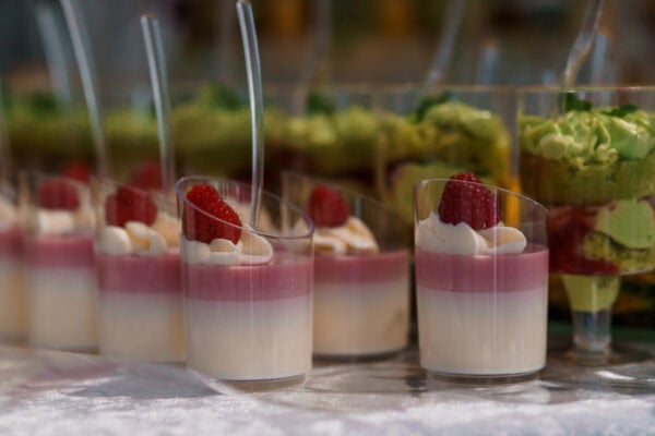 Elegant Dessert Glasses with Raspberry and Pistachio Layers on Display.